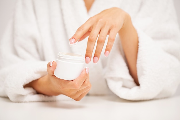 Photo woman applies moisturizer cream for hand skin care