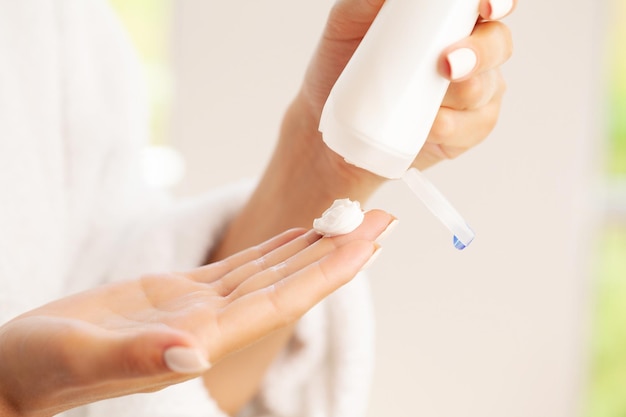 A woman applies moisturizing hand cream at home