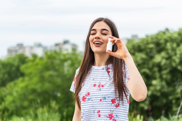 Woman applies nasal spray