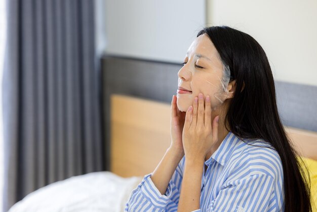 Woman apply the facial mask on face at home