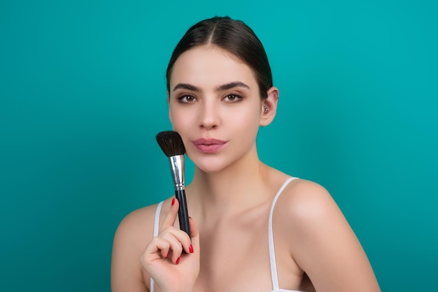 Woman apply powder on face beauty makeup portrait of female model with cosmetic brush perfect soft