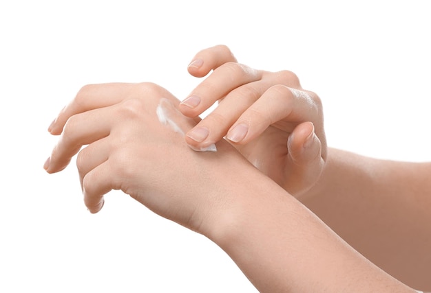 Woman applying body cream onto skin against white background