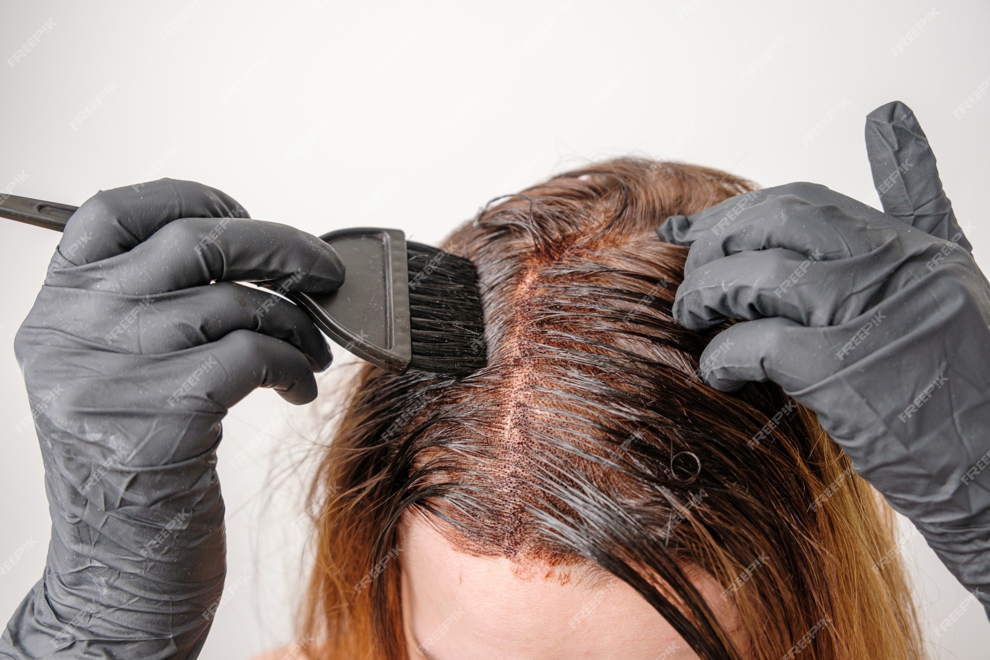Premium Photo | Woman applying a color tint to the brown hair using a brush. dyeing of gray roots of hair at home. Premium Photo | Woman applying a color tint to the brown hair using a brush. dyeing of gray roots of hair at home.