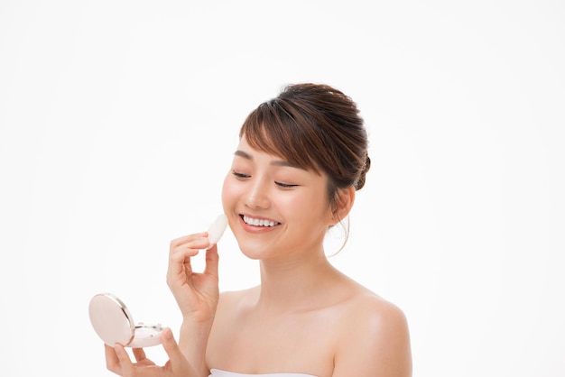 Woman applying cosmetic powder puff on her face