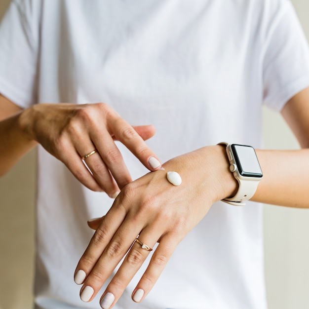 Woman applying cream on hand