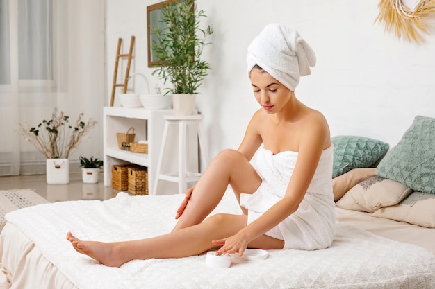 Woman applying cream on her legs