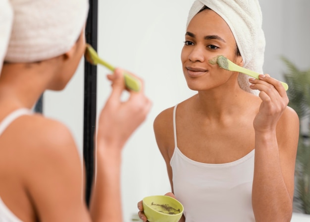 Woman applying a homemade mask on her face