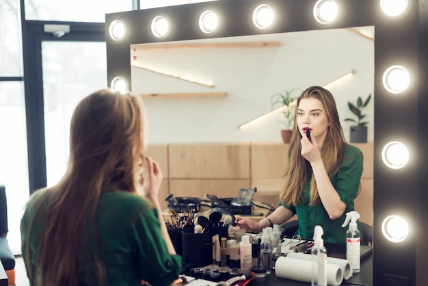 Photo woman applying lipstick