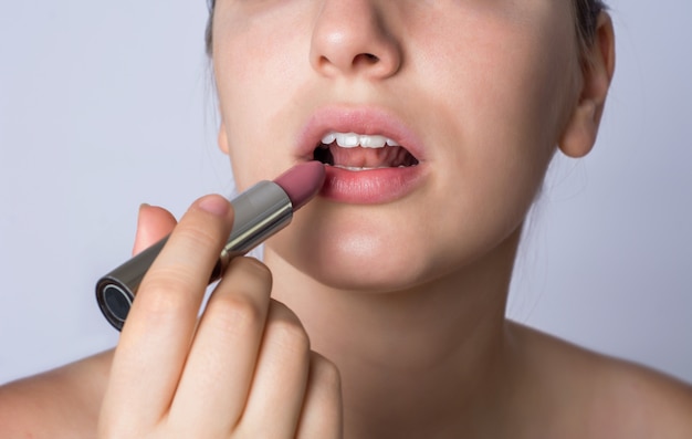 Woman applying lipstick.