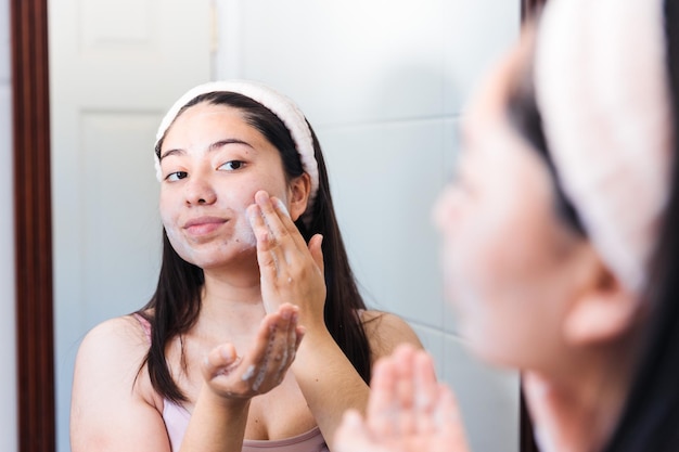 A woman applying a lotion to her face