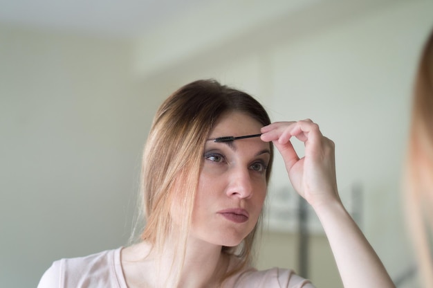 Photo woman applying make-up at home