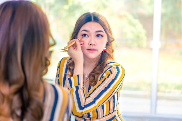 写真 自宅でマスカラを塗っている女性