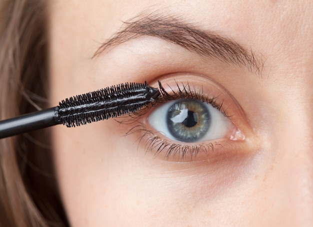 Woman applying mascara