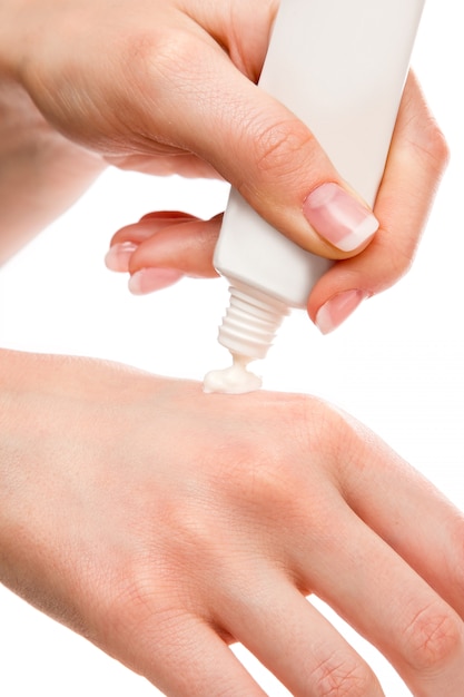 Woman applying moisturizer cream on hands