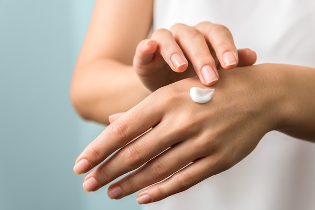 Photo woman applying moisturizer on her hands