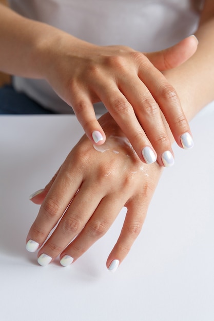 Woman applying moisturizer to her hands