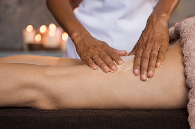 Woman applying moisturizer for leg massage