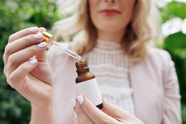 Woman applying moisturizing essence