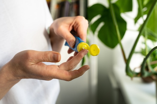 Woman applying moisturizing nourishing balm to her finger to prevent dryness and chapping her lips