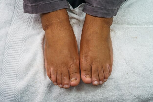 Woman applying nail polish to toenails in spa center