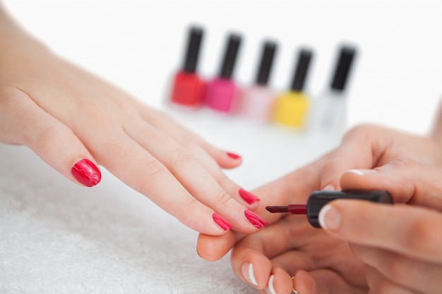 Woman applying nail varnish to finger nails