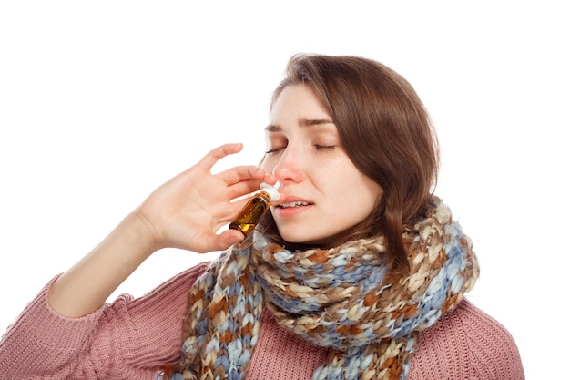 Woman applying nasal spray