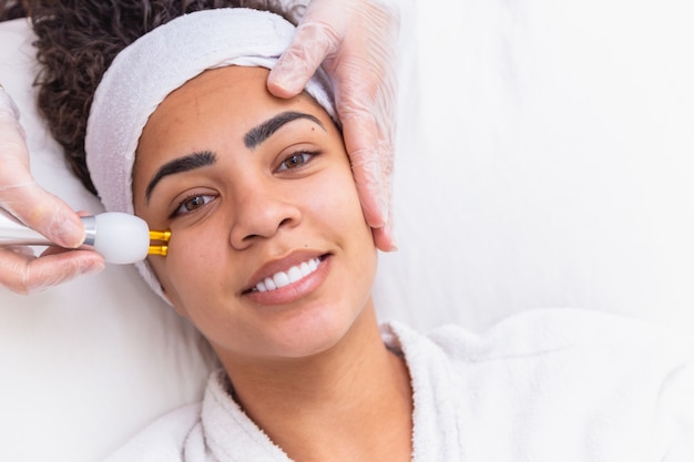 Woman applying plasma jet on her face