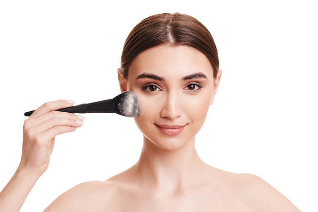 Woman applying powder with make up brush