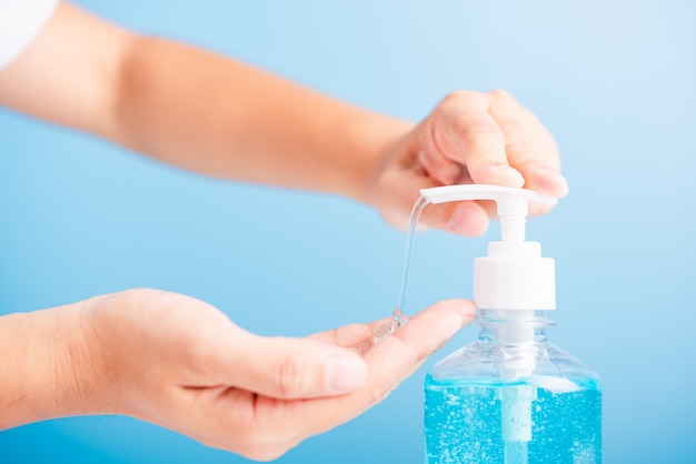 Photo woman applying press sanitizer alcohol gel pump to hand