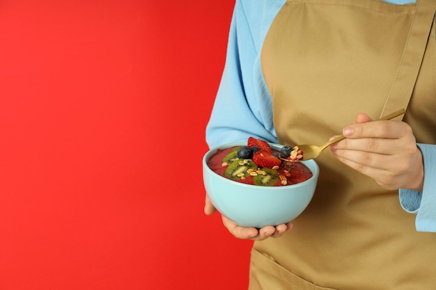 Woman in apron with smoothie with different ingredients