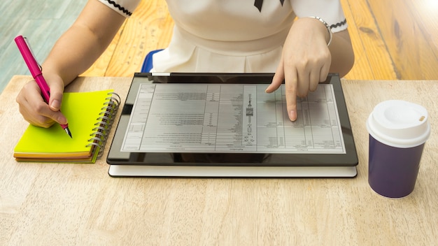 Foto la donna sta leggendo un ebook di testo del touch screen della compressa con il taccuino