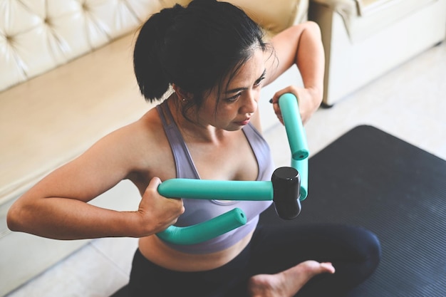 Woman arm exercises in her hands sport recreation health care concept sporty woman exercise muscles in sportswear with dumbbell at home in the living room woman exercising at home