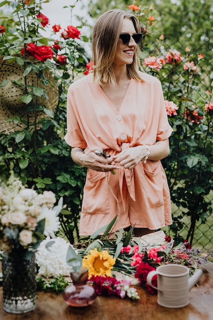 Donna che sistema i fiori in un giardino