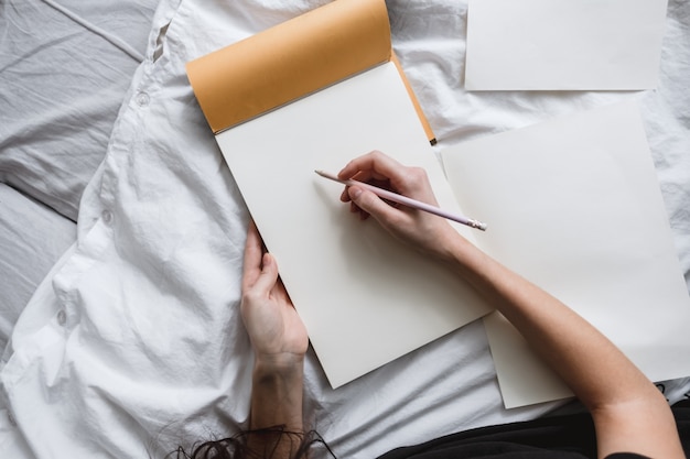 Woman artist draws in a sketchbook at home