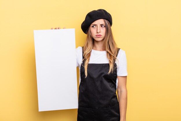 Foto artista donna triste sconvolto o arrabbiato e guardando al concetto di tela vuota laterale