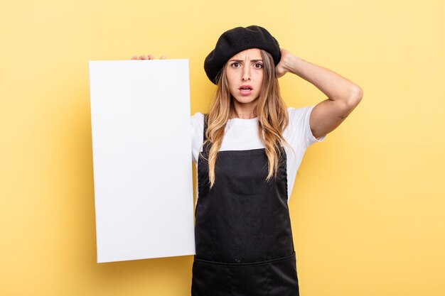 Woman artist feeling stressed, anxious or scared, with hands on head empty canvas concept