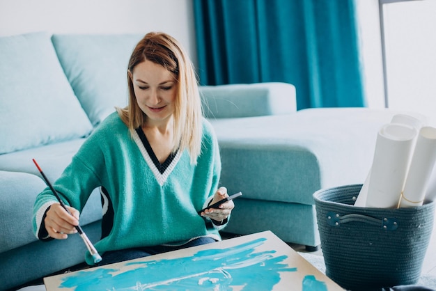 Woman artist painting a picture at home