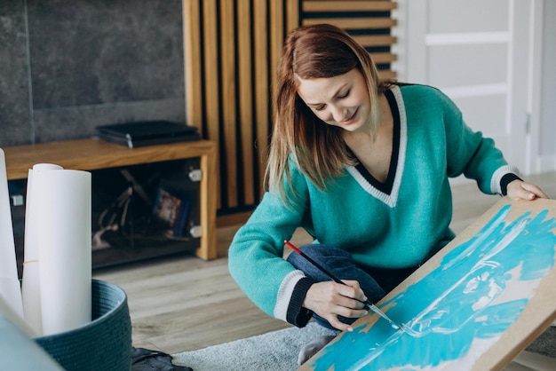 Woman artist painting a picture at home