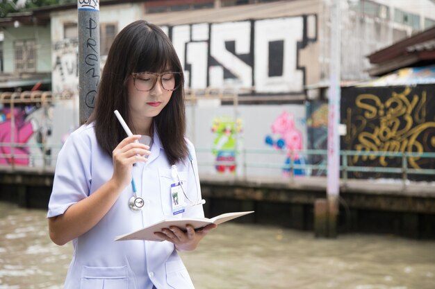 Woman Asian doctor  White Shirt suit with stethoscope outdoor Hospital.