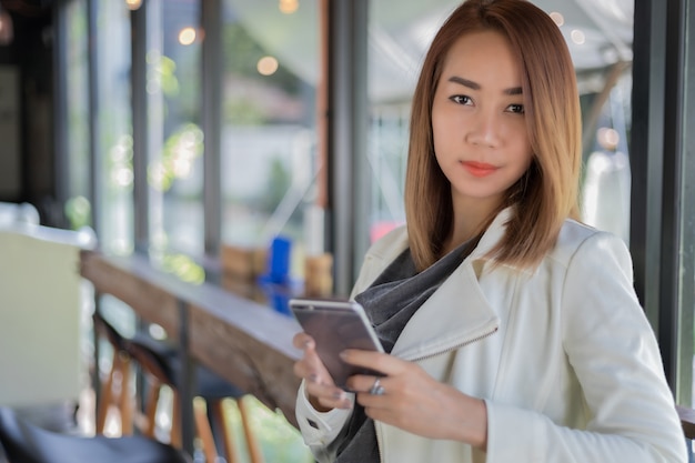온라인 쇼핑 및 fr 동안 커피 숍에서 휴대 전화로 전화를 사용하여 여자 아시아