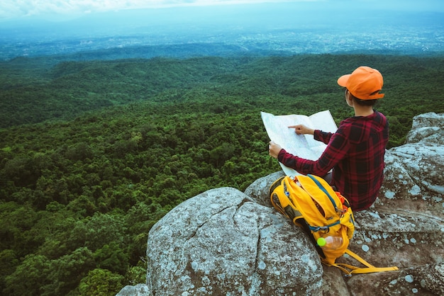 Foto viaggio asiatici donna rilassarsi in vacanza. visualizza la mappa esplora le montagne