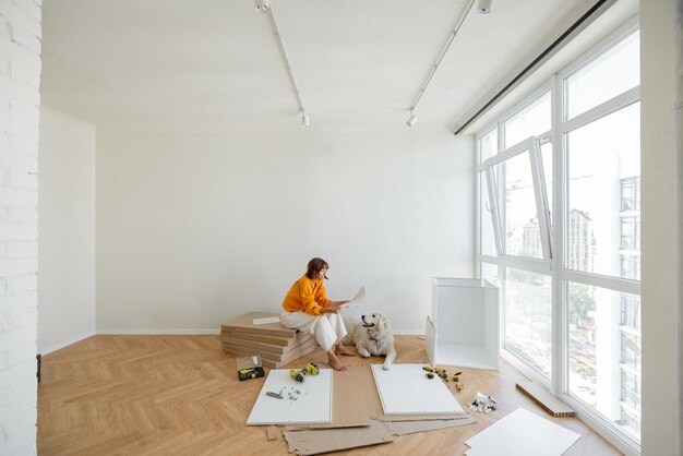 Woman Assembles Furniture At Home With Dog