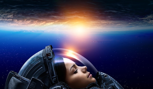 惑星軌道上の船外活動をしている女性宇宙飛行士。