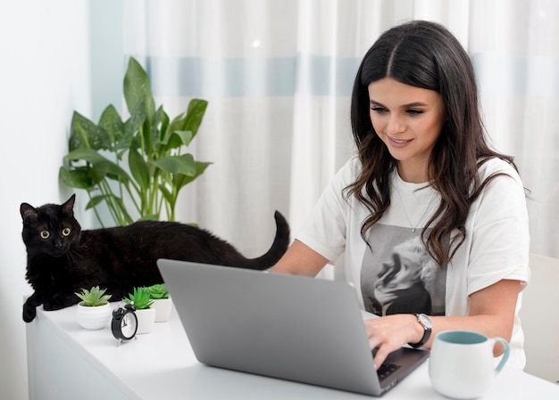 写真 女性の自宅のデスクでの作業と猫