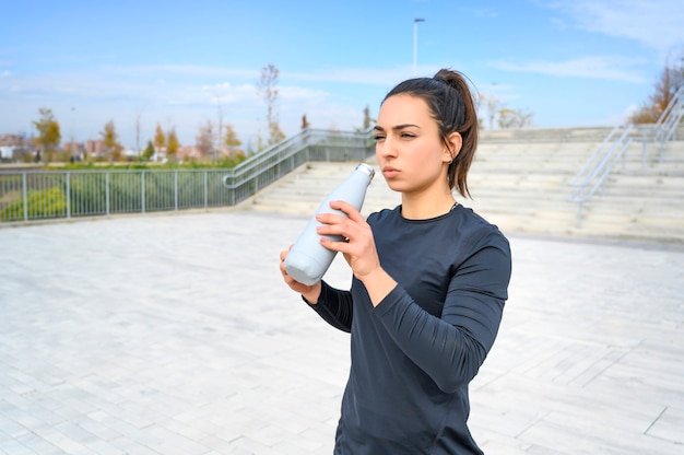 Woman athlete drinking water