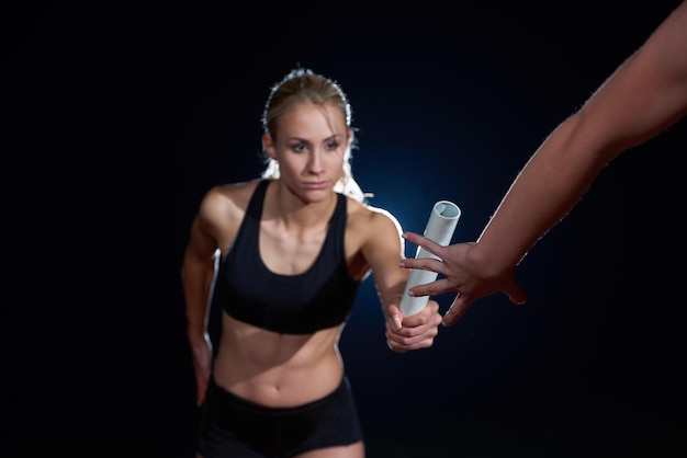 リレーレースでバトンを渡す女性の運動ランナー