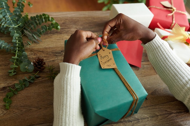 Woman attaching merry christmas tag