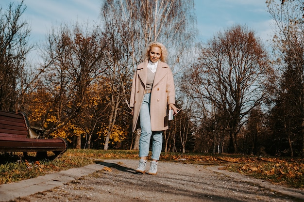 Woman in an autumn coat holds a book