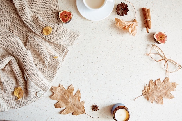 Woman autumn outfit background with sweater glasess among figs and leaves Autumn aesthetic coffee time near candle Copy space
