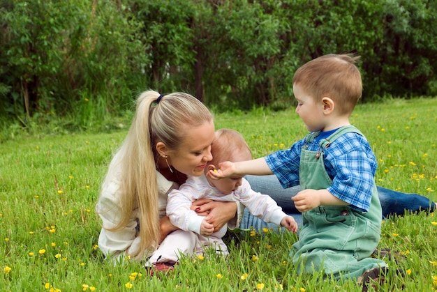 Foto una donna e un bambino sono seduti nell'erba con un bambino